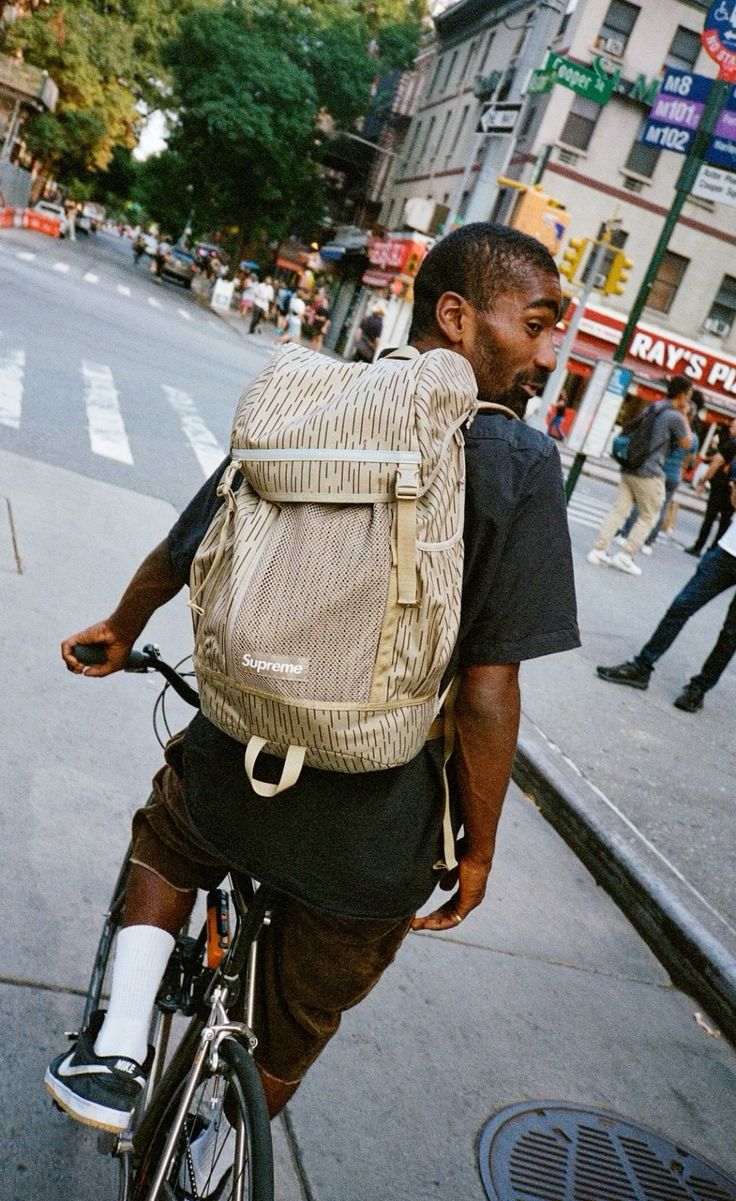 Cyclist in the city wearing a beige travel backpack