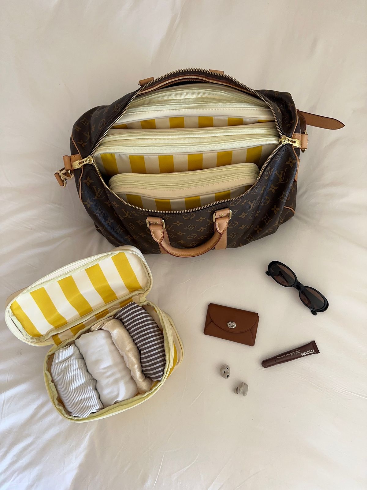 Brown duffel bag packed with yellow striped organizers